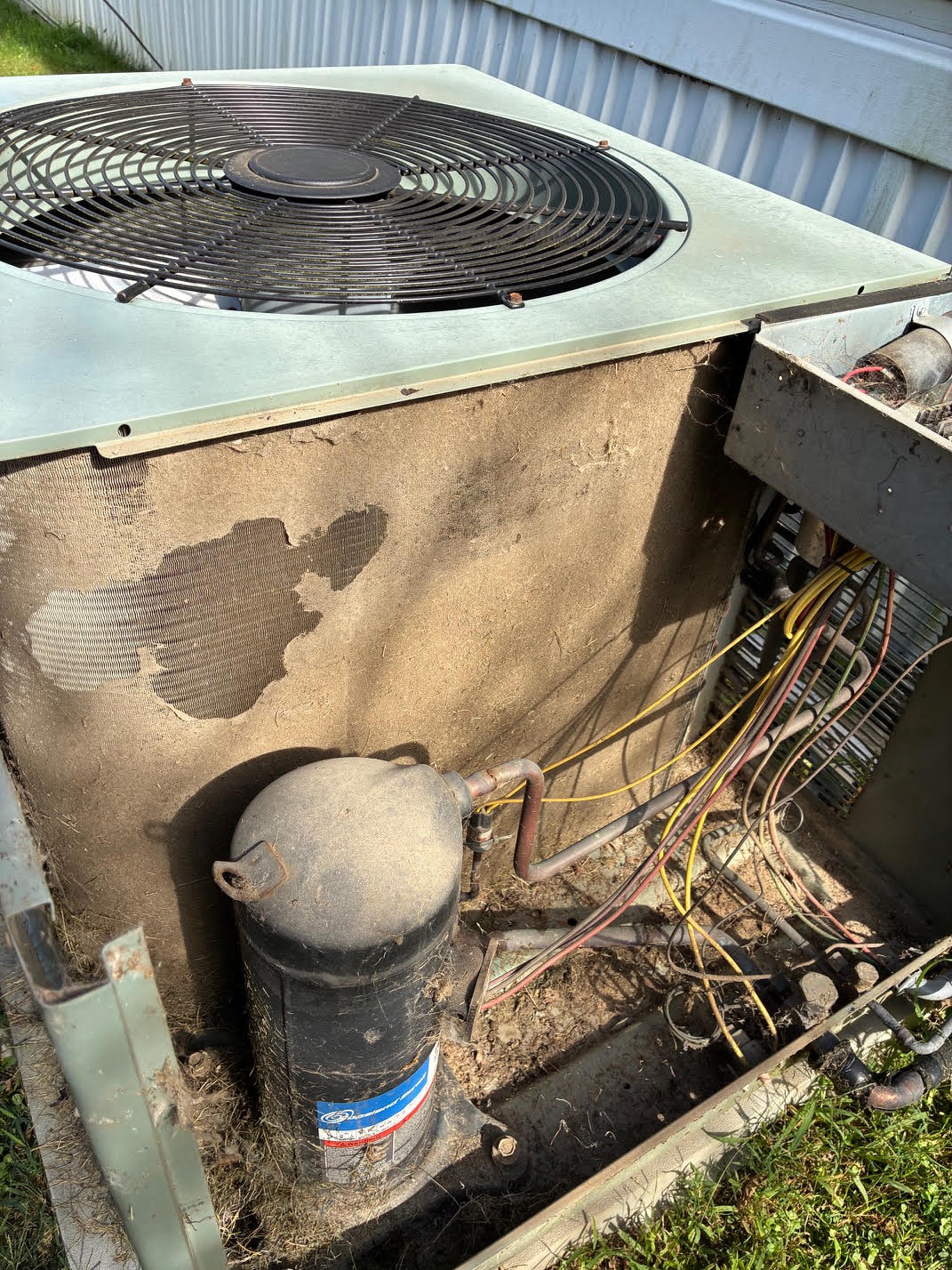 Armstrong's Heating & Cooling technician performing air conditioning maintenance